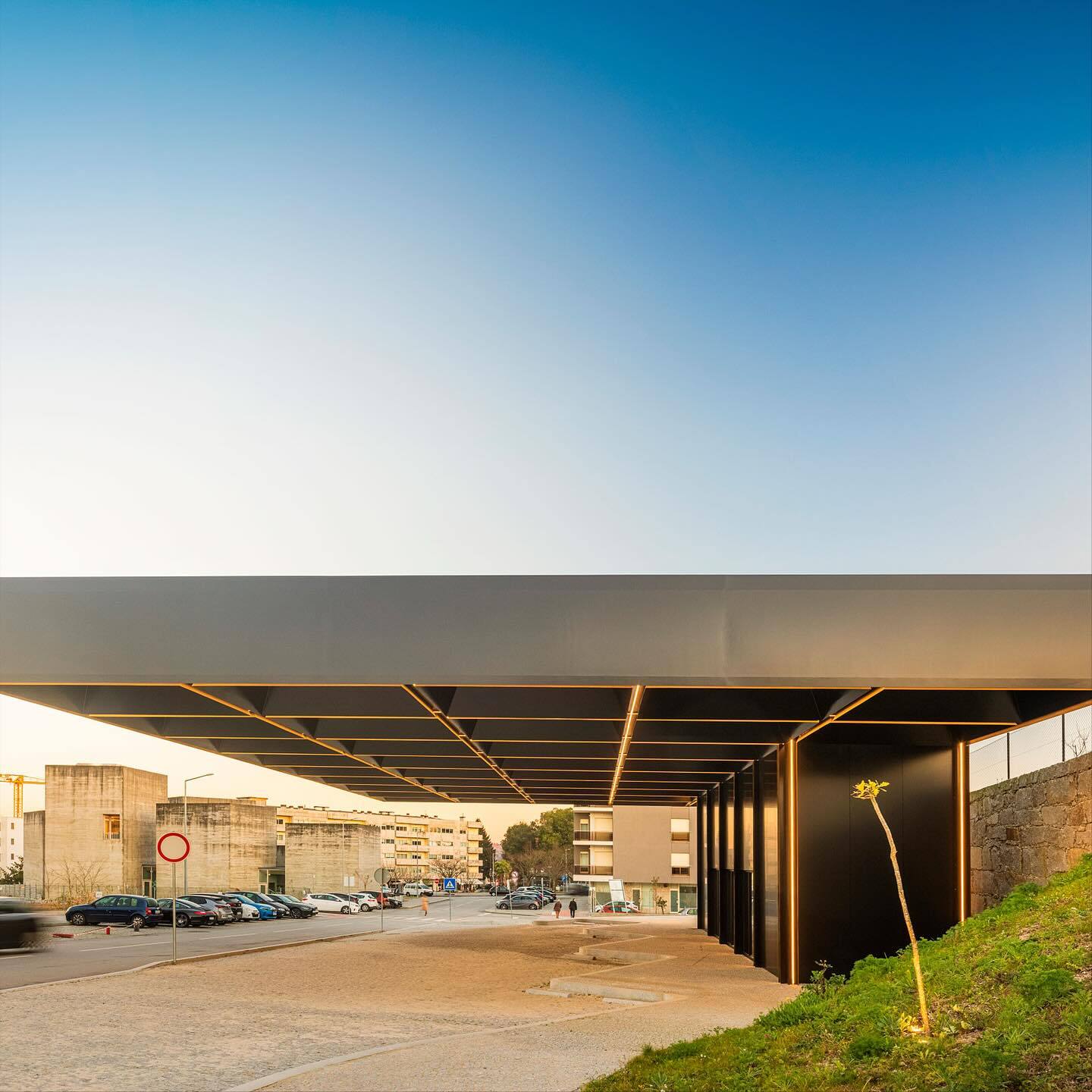 تصویری از نمای خارجی مرکز چندوجهی (Intermodal Center) در لوزادا، واقع در شمال شرقی پورتو پرتغال، که توسط شرکت معماری Spaceworkers طراحی شده است. این ساختمان با حجم‌های هندسی خاص و مدرن و استفاده از مصالح سفید یا روشن، به عنوان یک نشانه‌ی شهری و قطب جدید ف